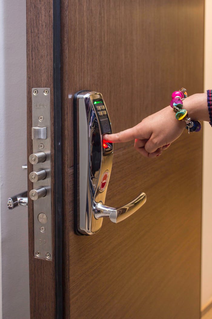pexels-photo-7522609 A hand using fingerprint access on a digital security door lock, enhancing safety.